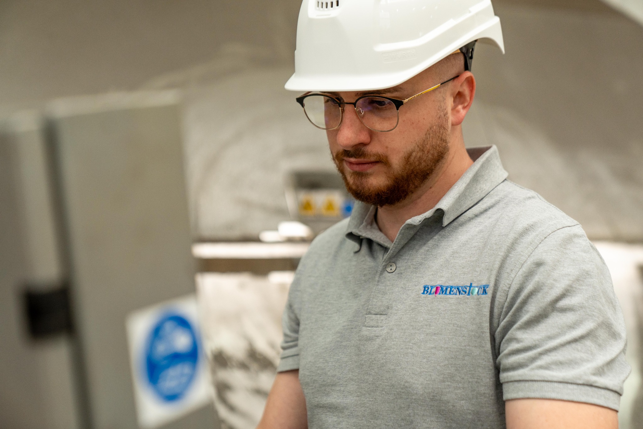 Mitarbeiter mit Schutzhelm und BLUMENSTOCK-Poloshirt in der Produktion