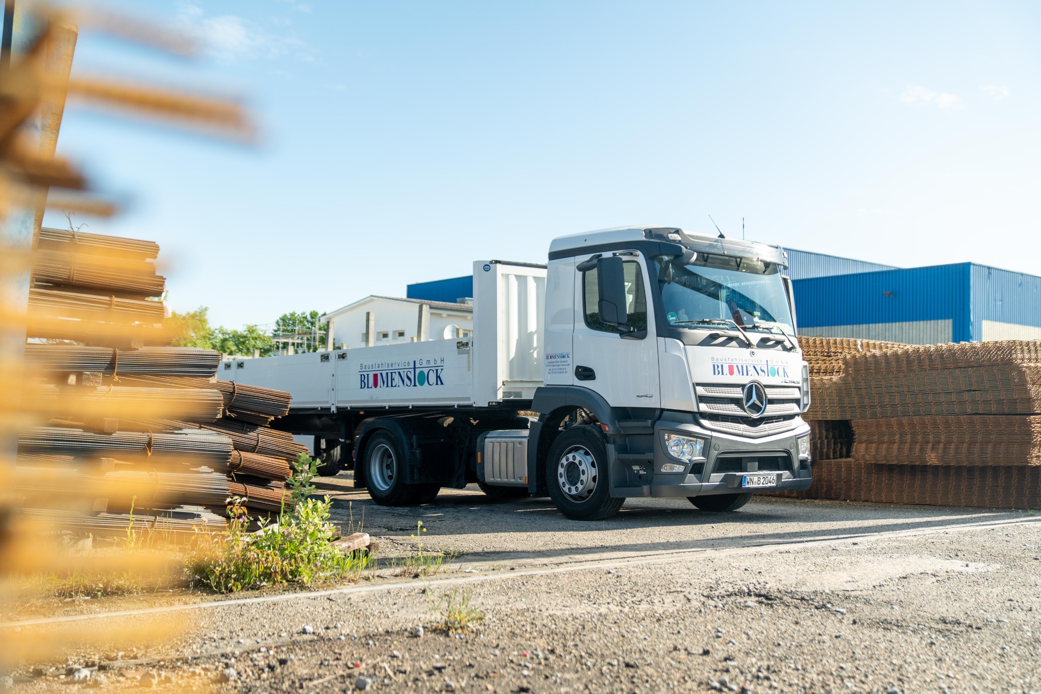 BLUMENSTOCK-Lkw zwischen gelagertem Betonstahl auf dem Betriebsgelände