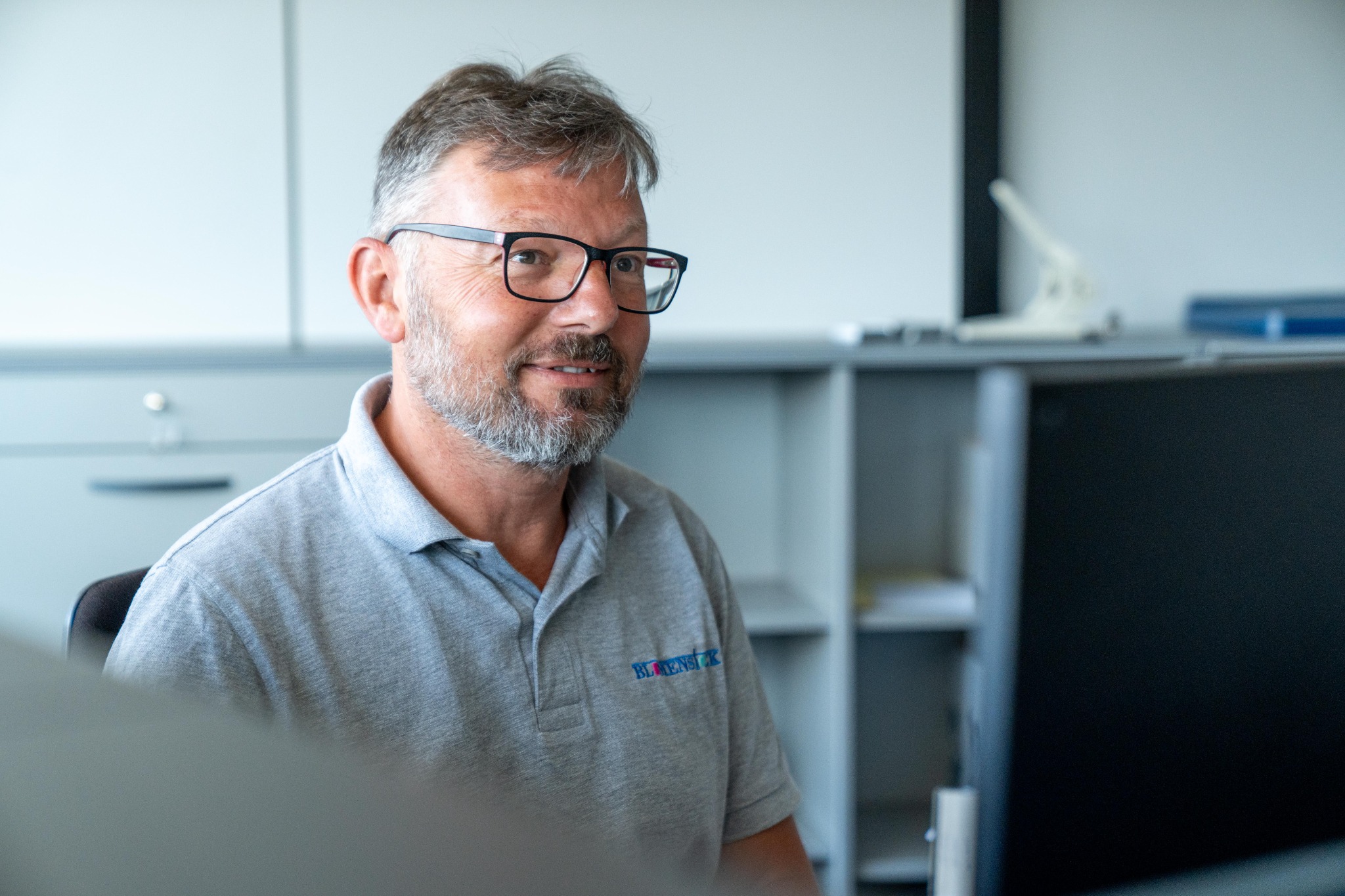 Mitarbeiter von BLUMENSTOCK bei der Arbeit am Bildschirm im Büro